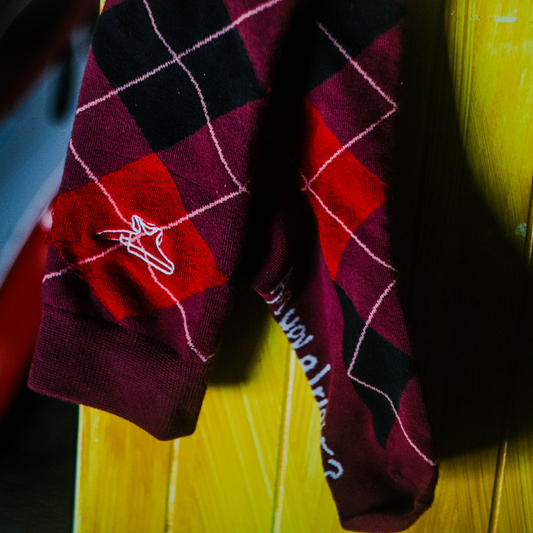 Detailed image of a pair of red knee-high tartan socks
